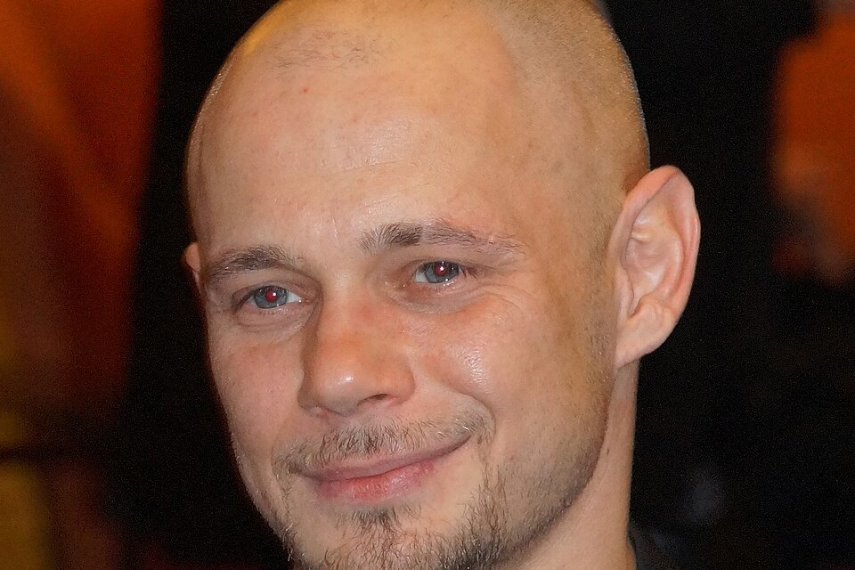 Antonio Wannek lächelt beim Askania Award 2016 in die Kamera, Porträt mit Glatze und kurzem Bart