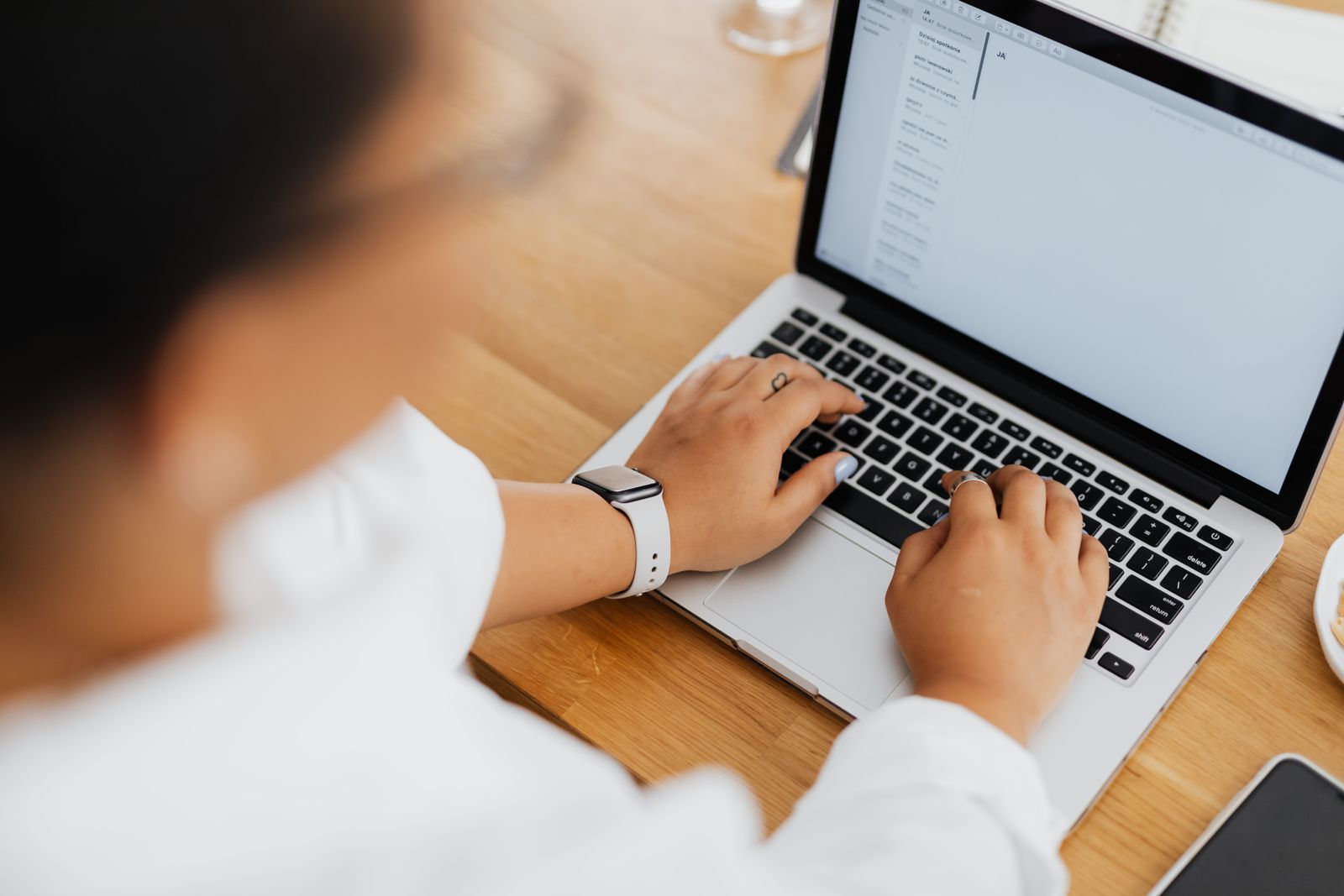 Nahaufnahme einer Person beim Tippen auf einer Laptop-Tastatur