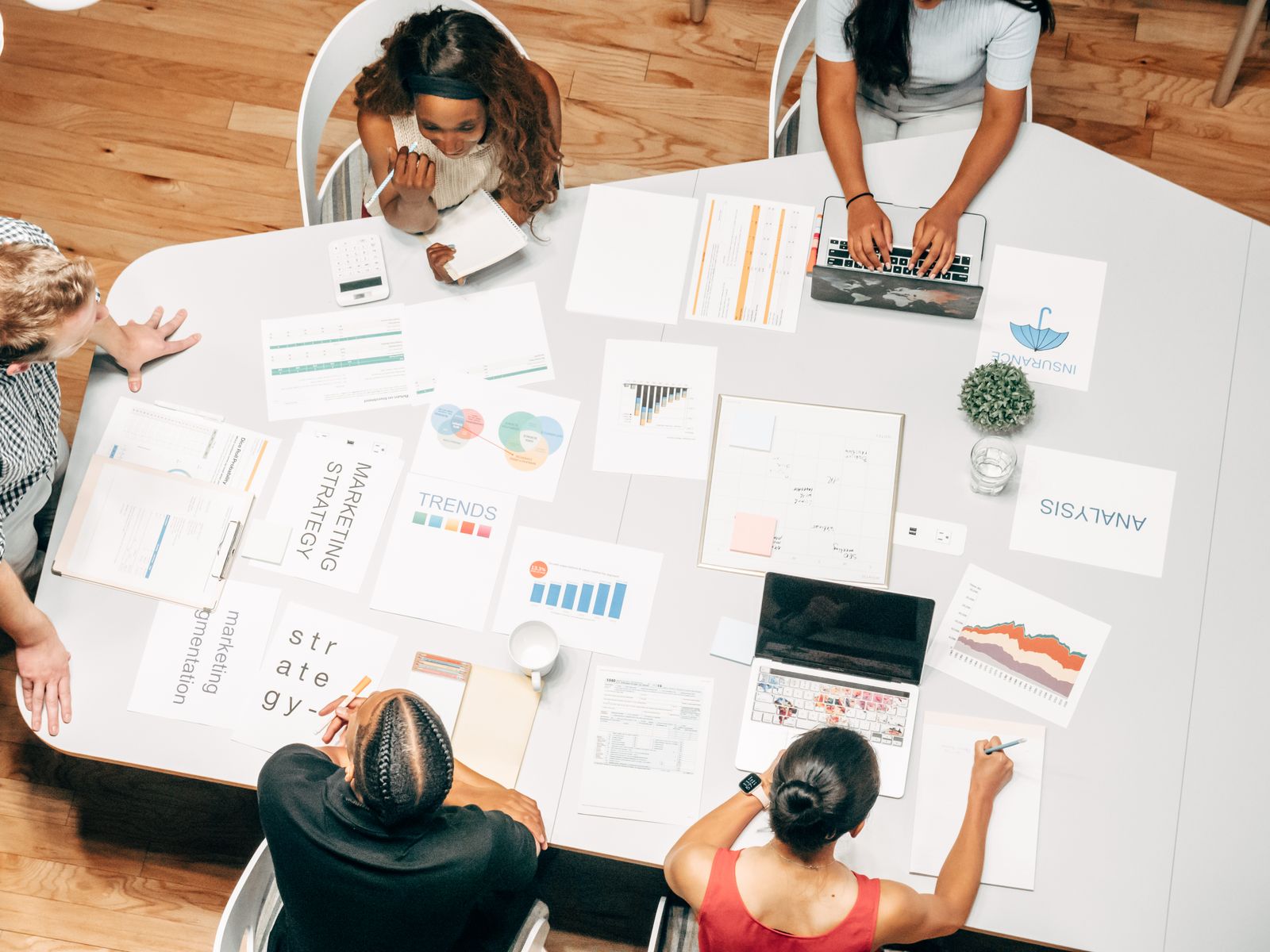 Team arbeitet von oben gesehen an einem Tisch an einer Marketingstrategie