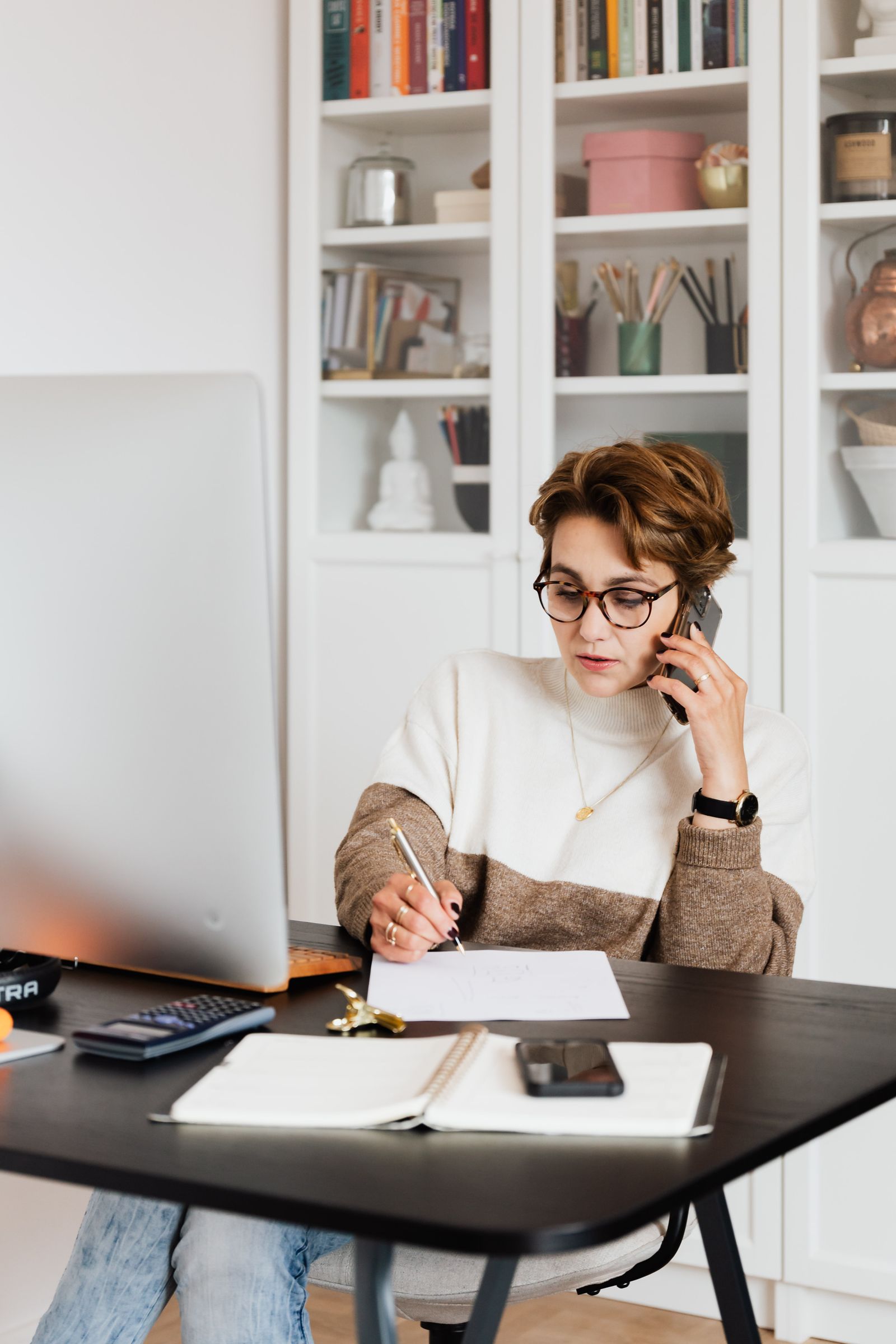 Moderne Geschäftsfrau in Business-Casual-Outfit telefoniert im Büro