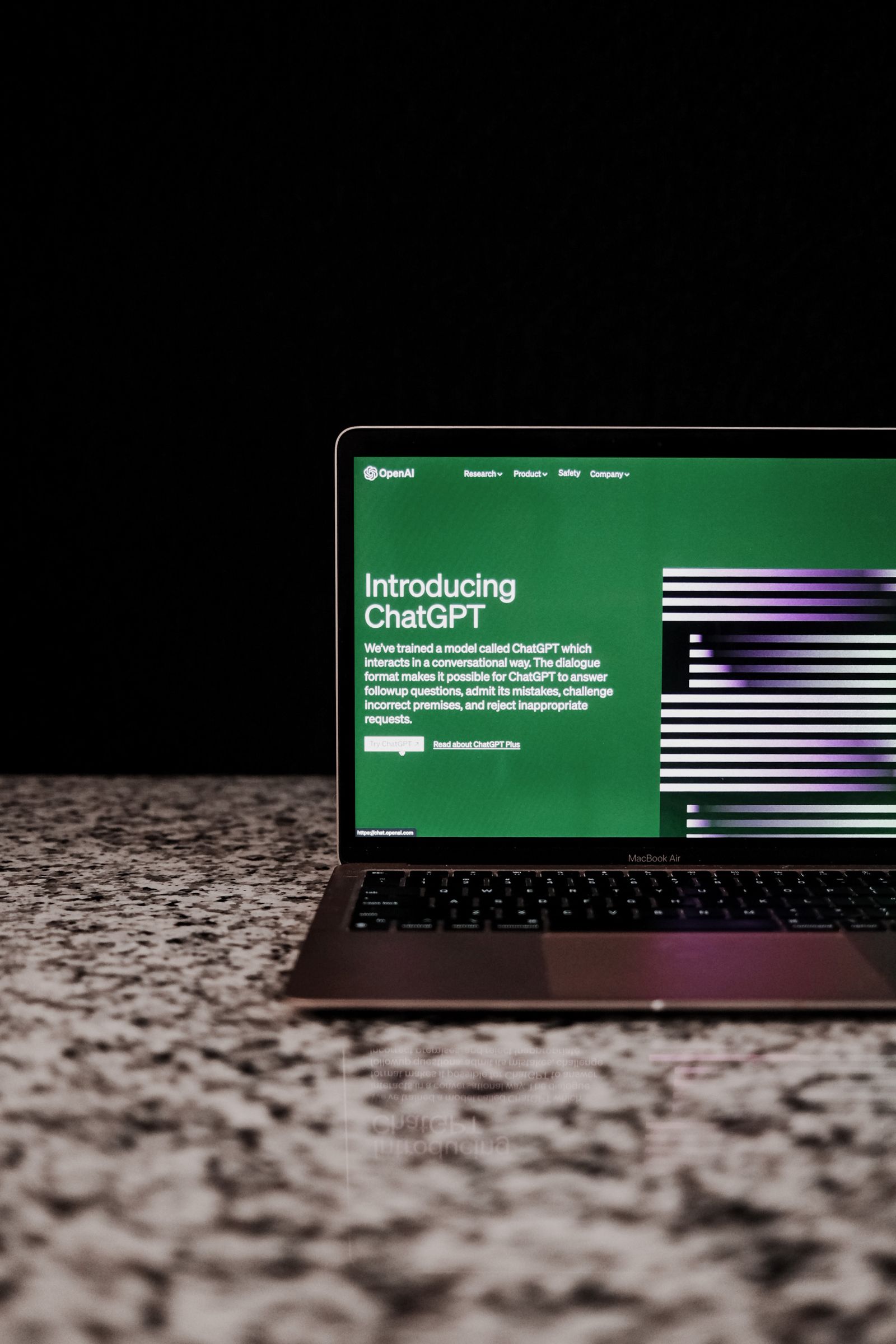 Laptop auf Marmortisch zeigt das ChatGPT-Interface im Browser