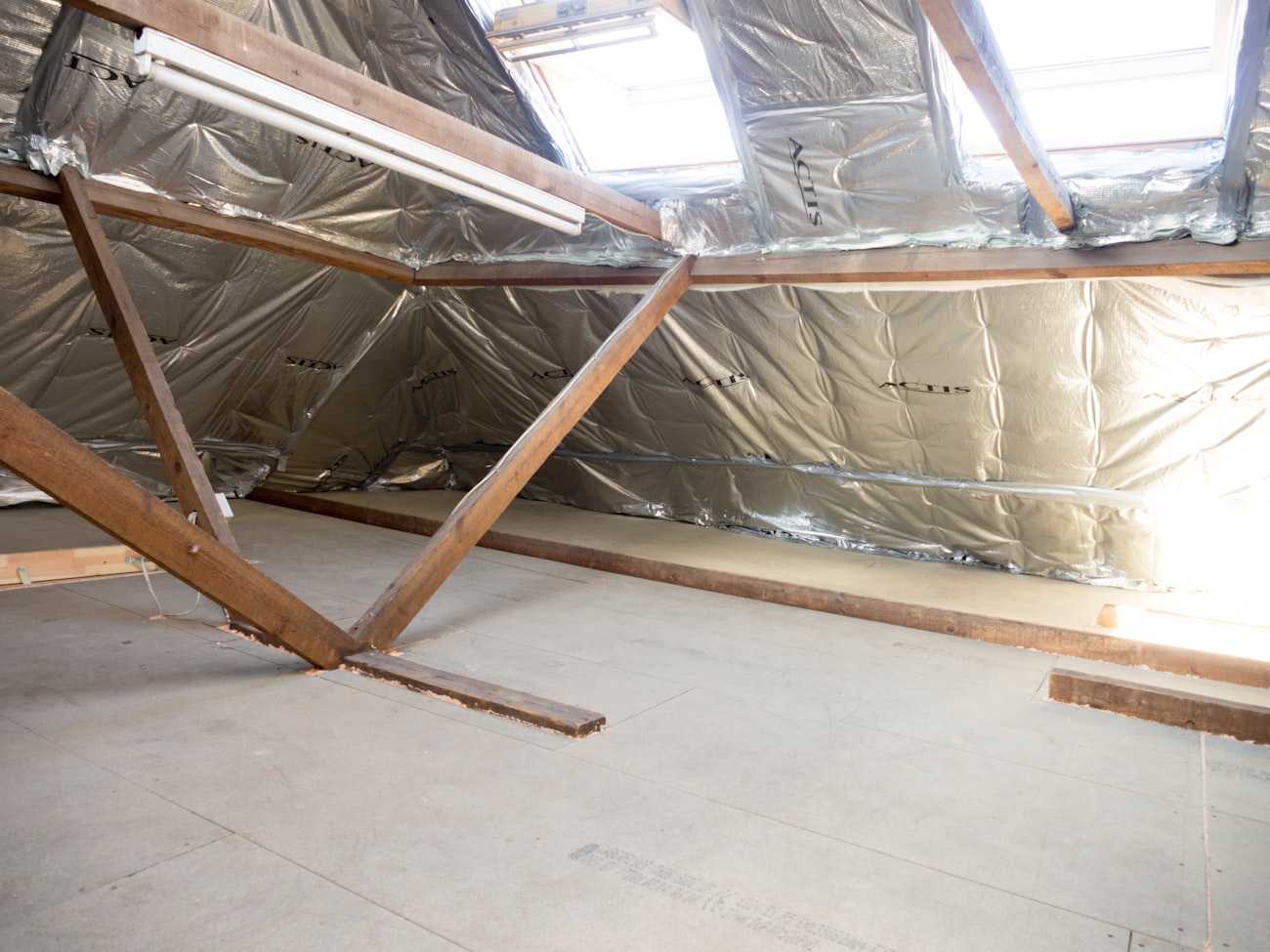 Ausgebauter Dachboden mit freiliegenden Holzbalken und Dachfenster