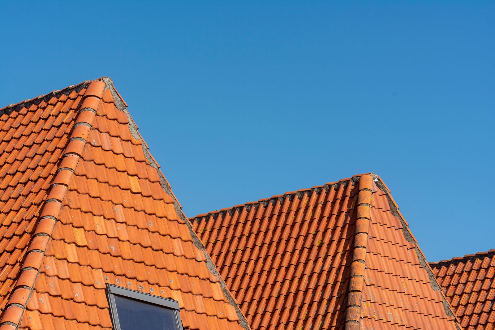Rote Dachziegel unter klarem blauem Himmel aus der Froschperspektive