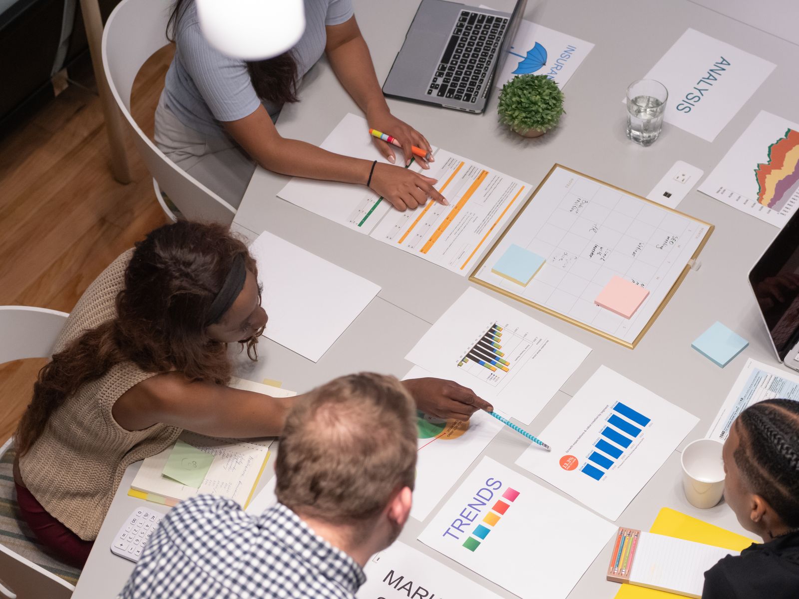 Team analysiert gemeinsam Diagramme und Auswertungen auf einem Besprechungstisch