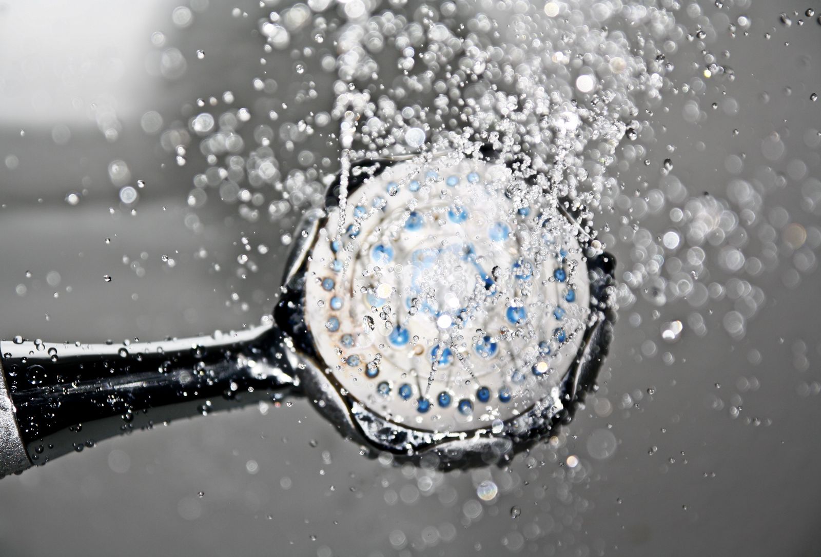 Duschkopf aus Chrom, aus dem Wasser in feinen Strahlen läuft