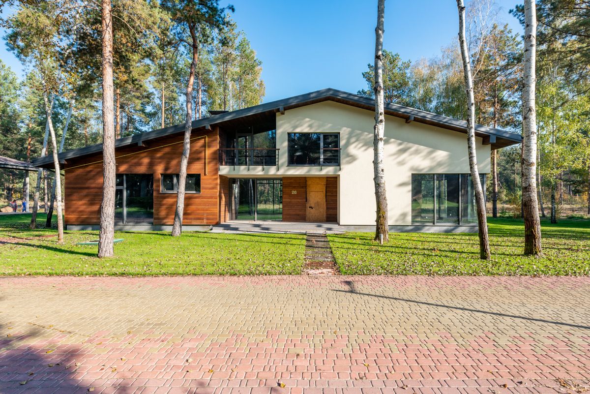 Modernes Wohnhaus mit großer Glasfront und Holzfassade im Abendlicht