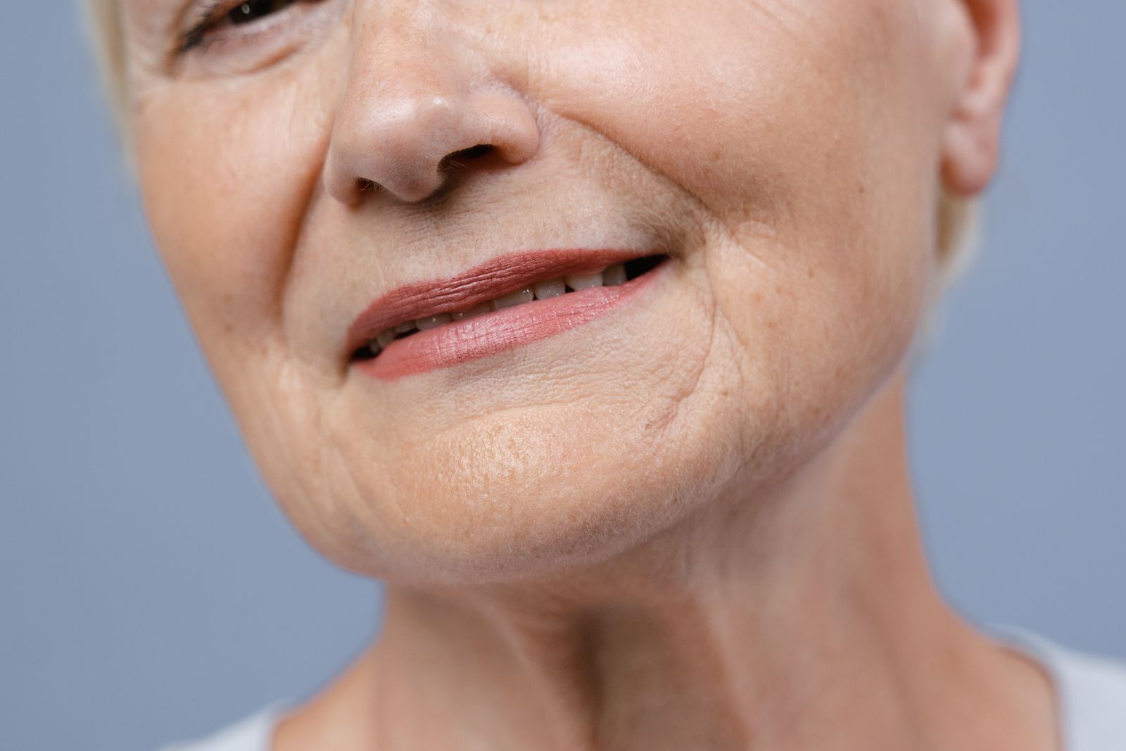 Untere Gesichtshälfte einer älteren Frau mit Lachfalten an Mund und Wangen