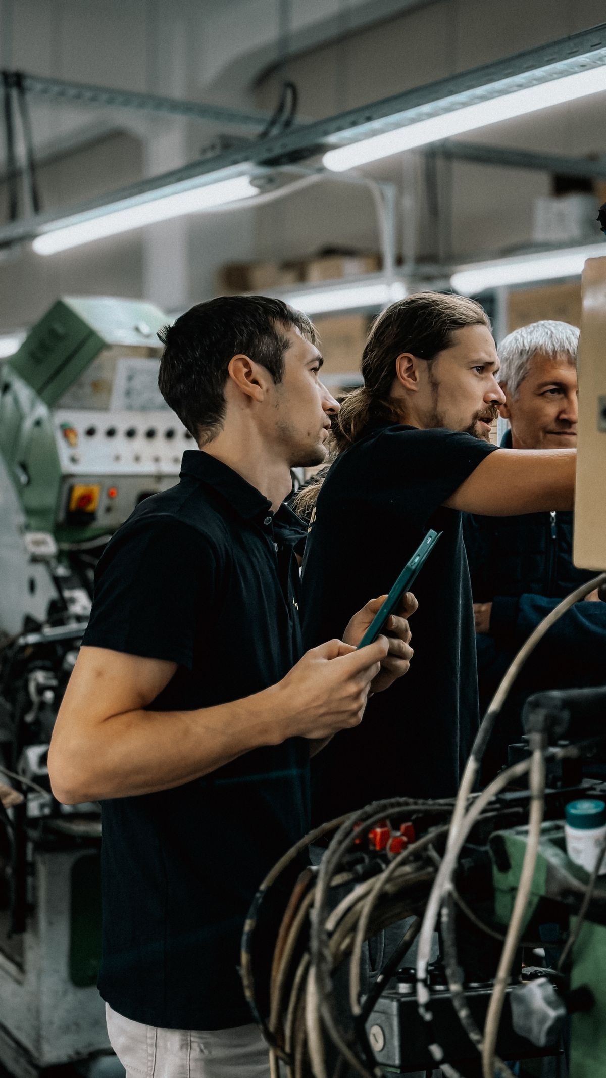 Zwei Ingenieure besprechen Maschinendaten in einer modernen Fertigungshalle