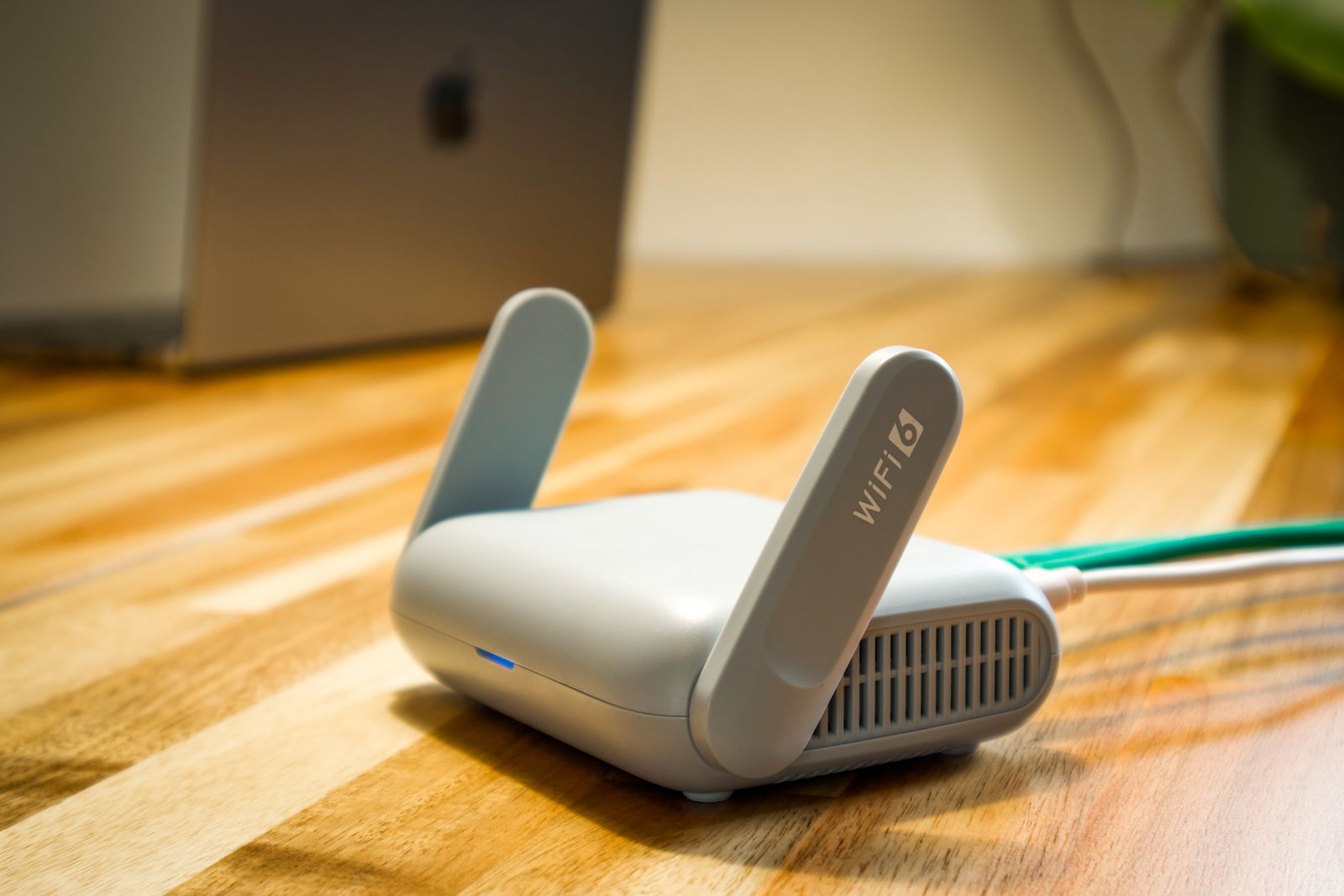Moderner WiFi 6 Router mit Antennen auf einem Holzschreibtisch