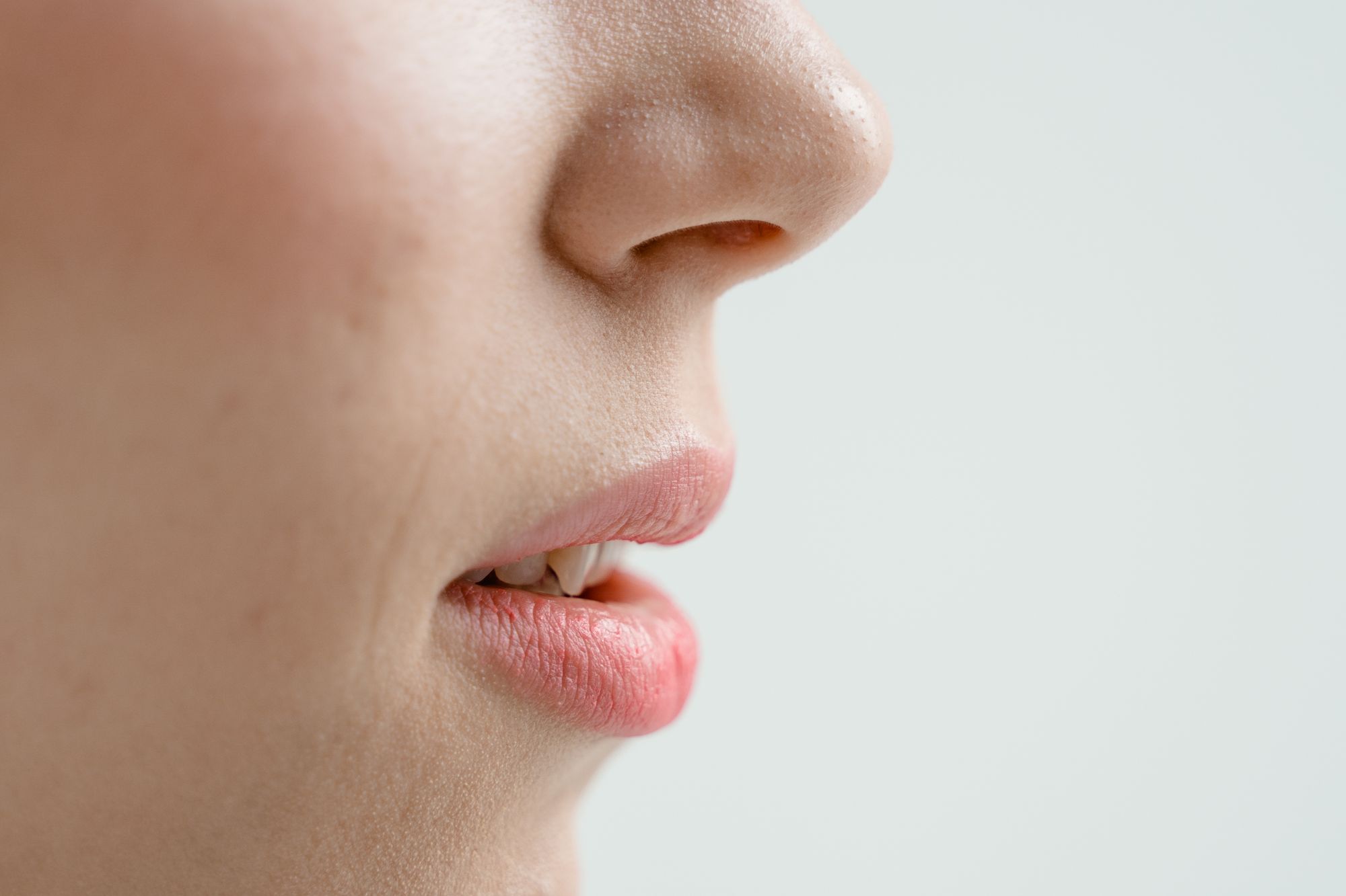 Seitliche Nahaufnahme von Nase und Lippen einer Frau mit sichtbarer Hautstruktur
