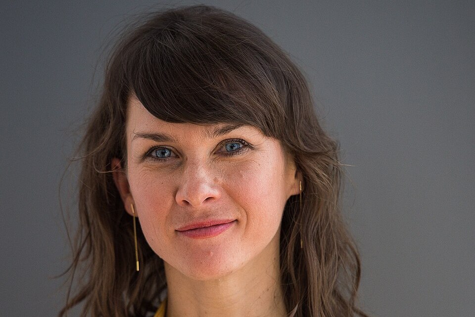 Kathrin von Steinburg im Porträt mit langen braunen Haaren und Pony vor grauem Hintergrund