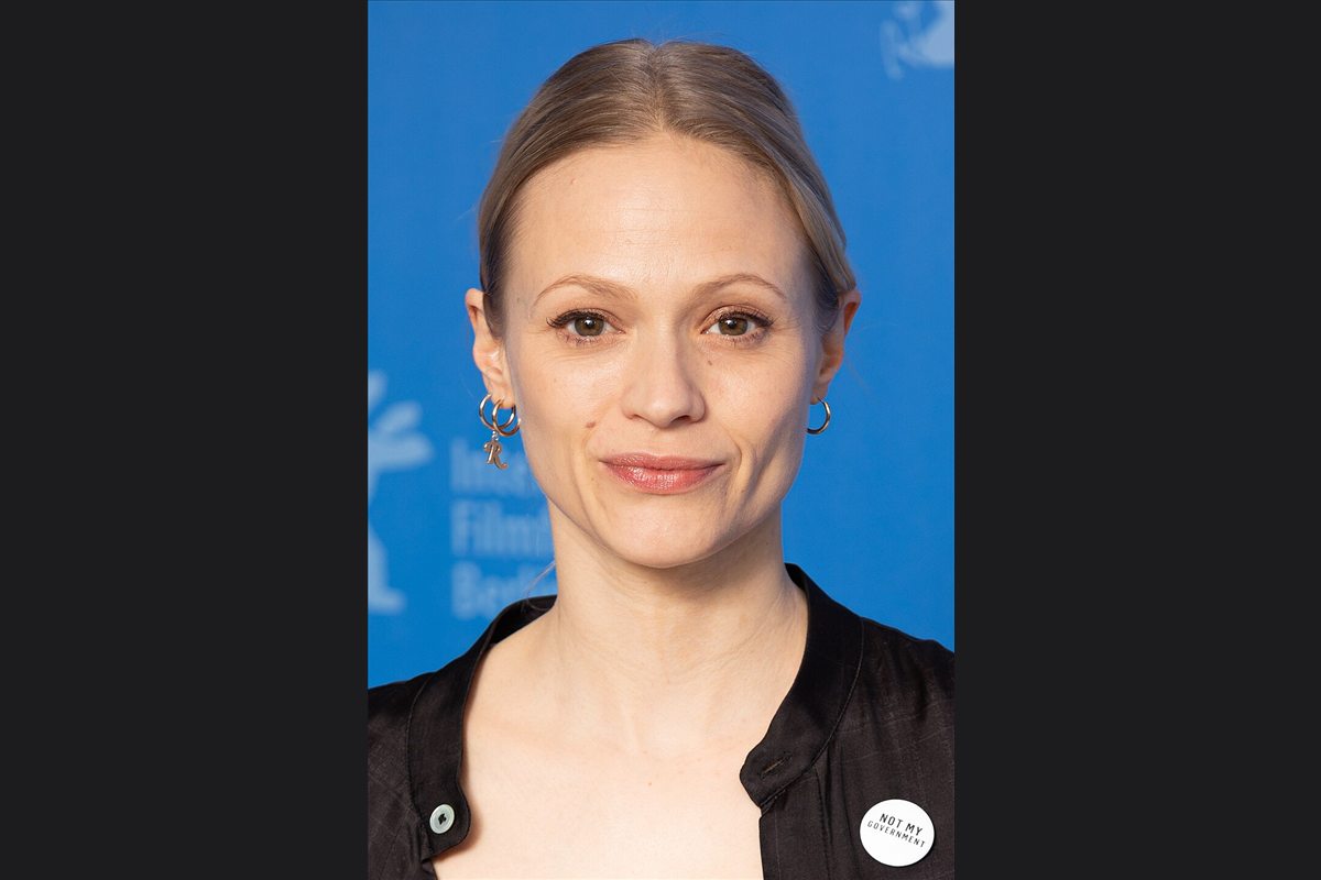 Mavie Hörbiger im Porträt vor blauer Pressewand bei der Berlinale 2019, Bild auf dunkler Fläche