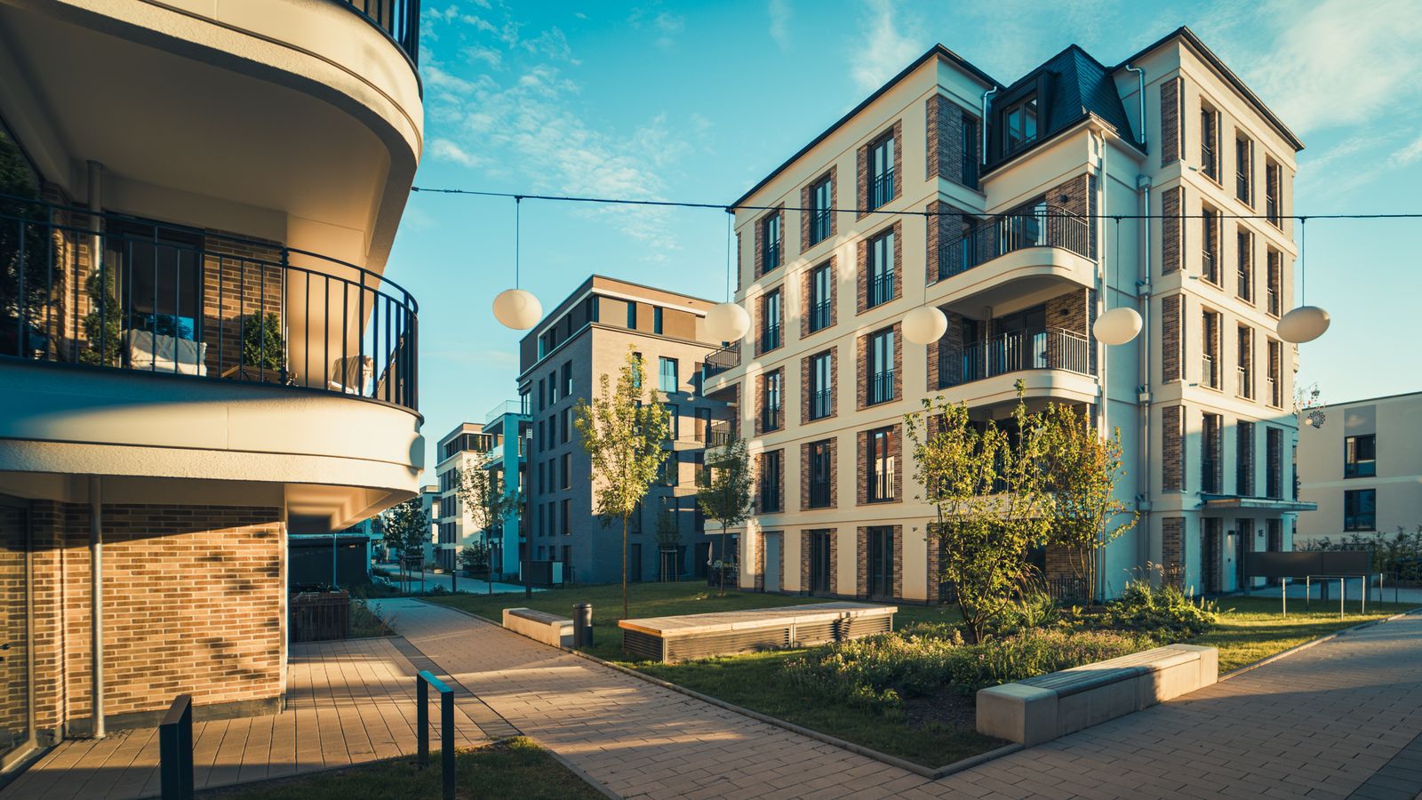 Modernes Mehrfamilienhaus mit vielen offenen Balkonen bei Tageslicht