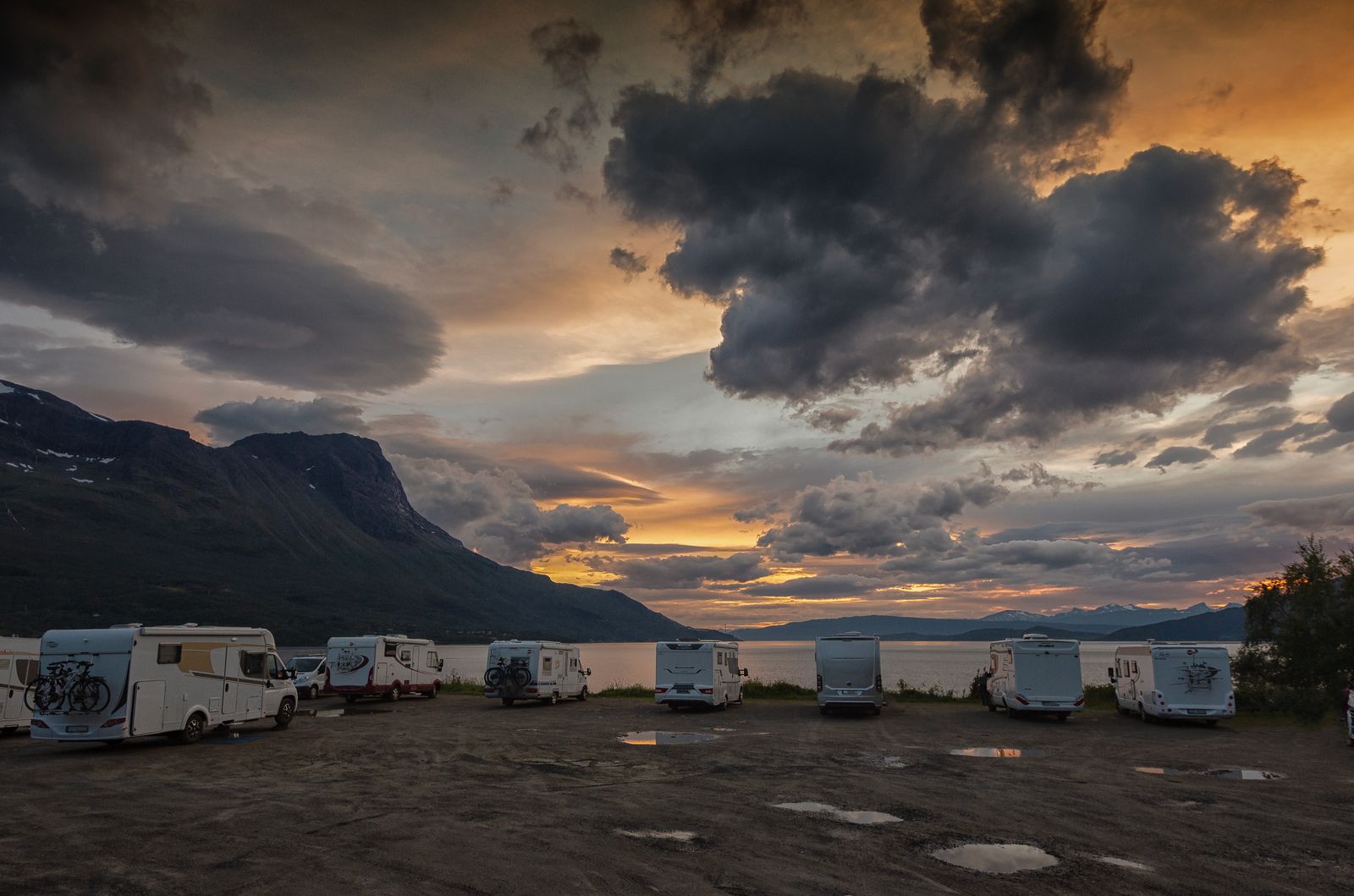 Wohnmobile stehen am Strand von Langstranda bei Narvik unter Abendhimmel