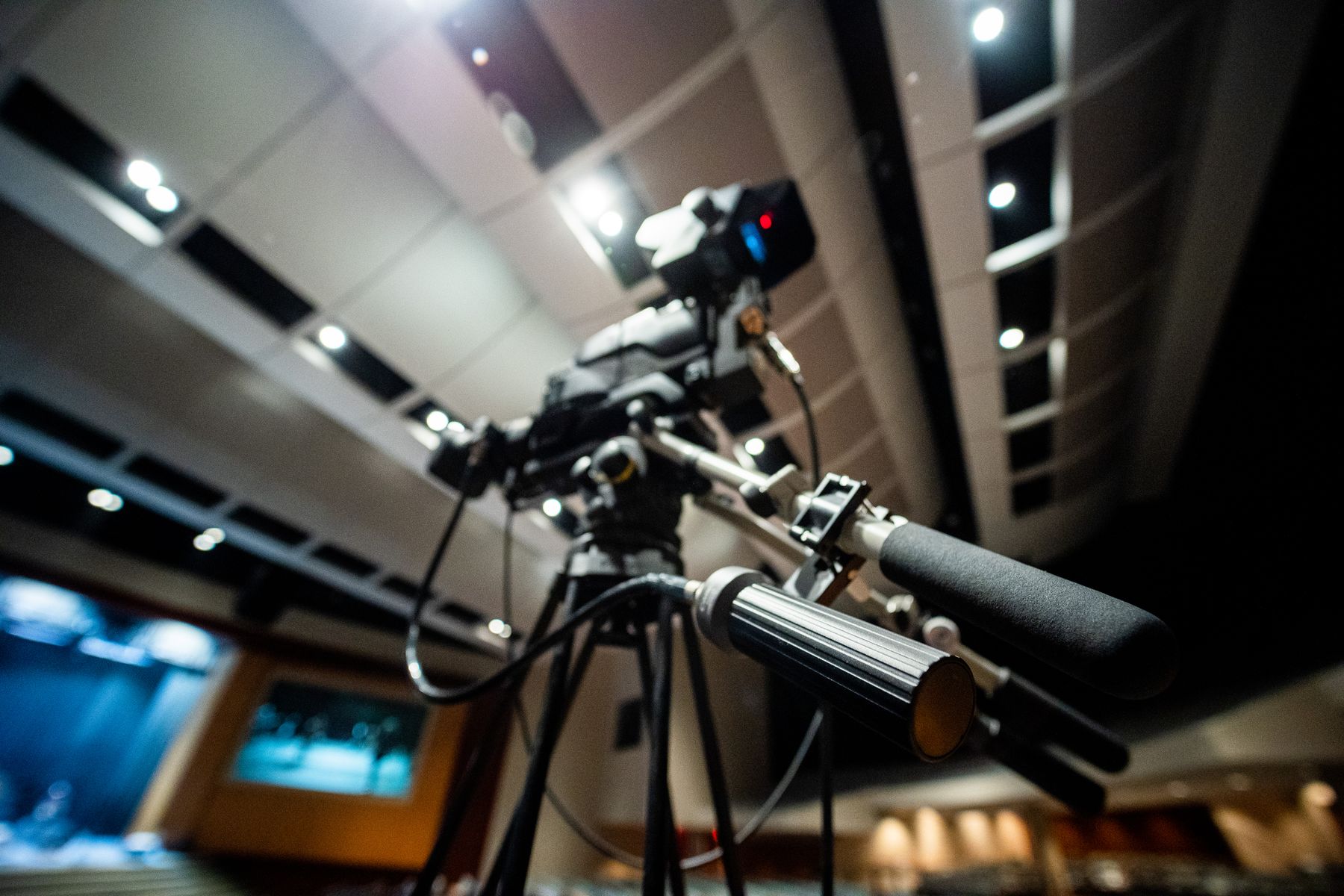 Professionelle Fernsehkamera mit Richtmikrofon auf einem Stativ in einem Studio, von unten fotografiert