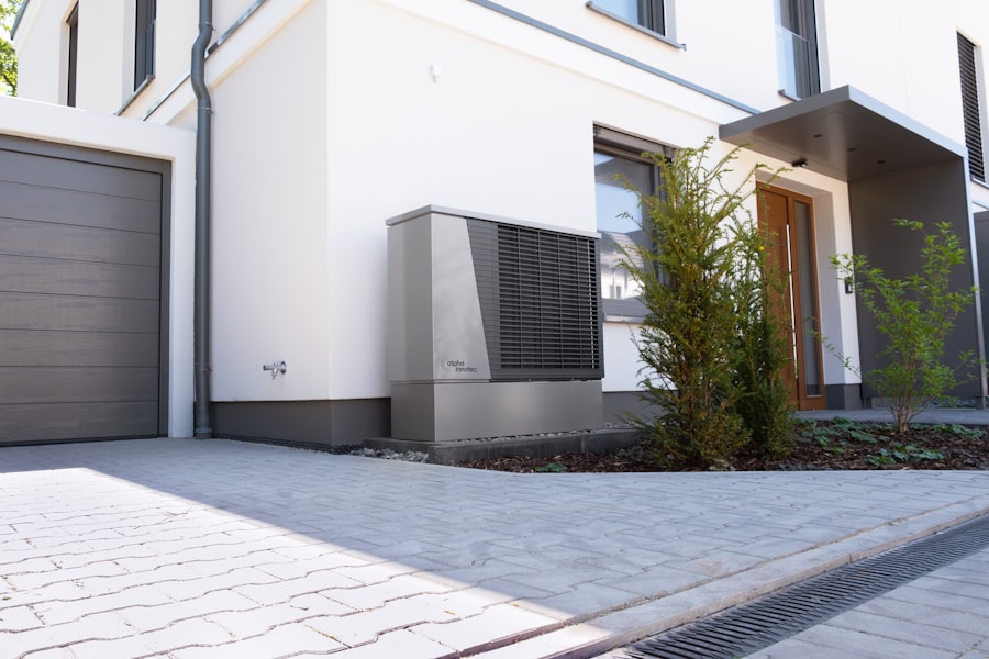 Moderne Wärmepumpe steht an der Außenwand eines Einfamilienhauses im Garten