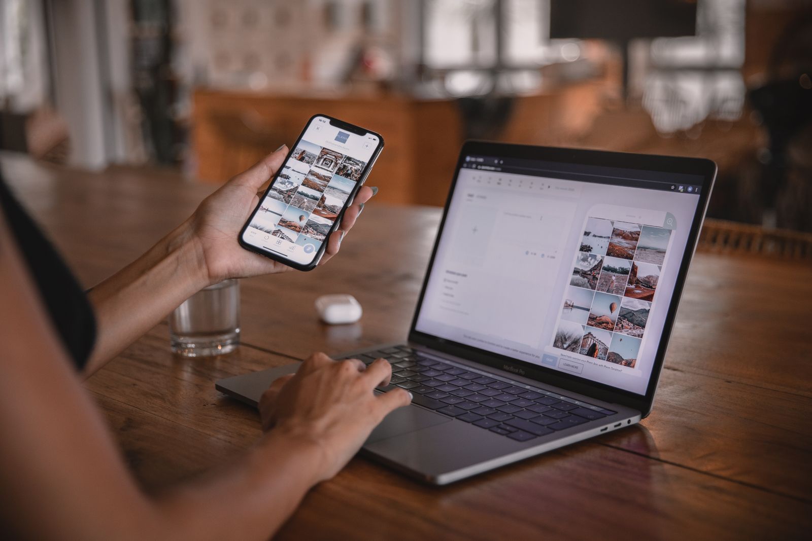 Frau arbeitet mit Smartphone und Laptop an Social-Media-Content