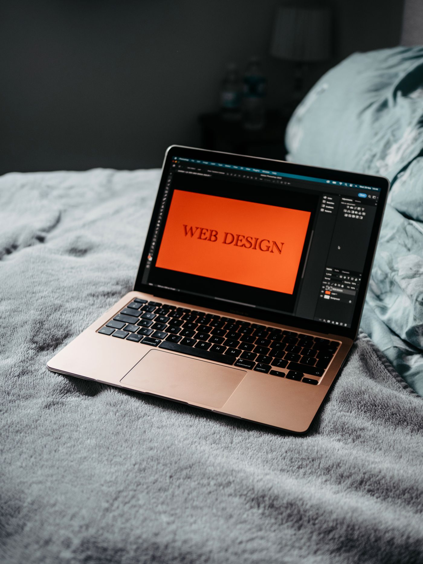 Aufgeklappter Laptop auf einem Bett zeigt eine Website im Designprozess