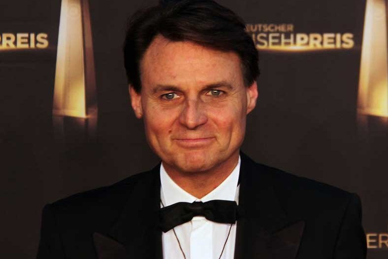 Wolfgang Bahro im Smoking mit Fliege vor der Fotowand des Deutschen Fernsehpreises 2012