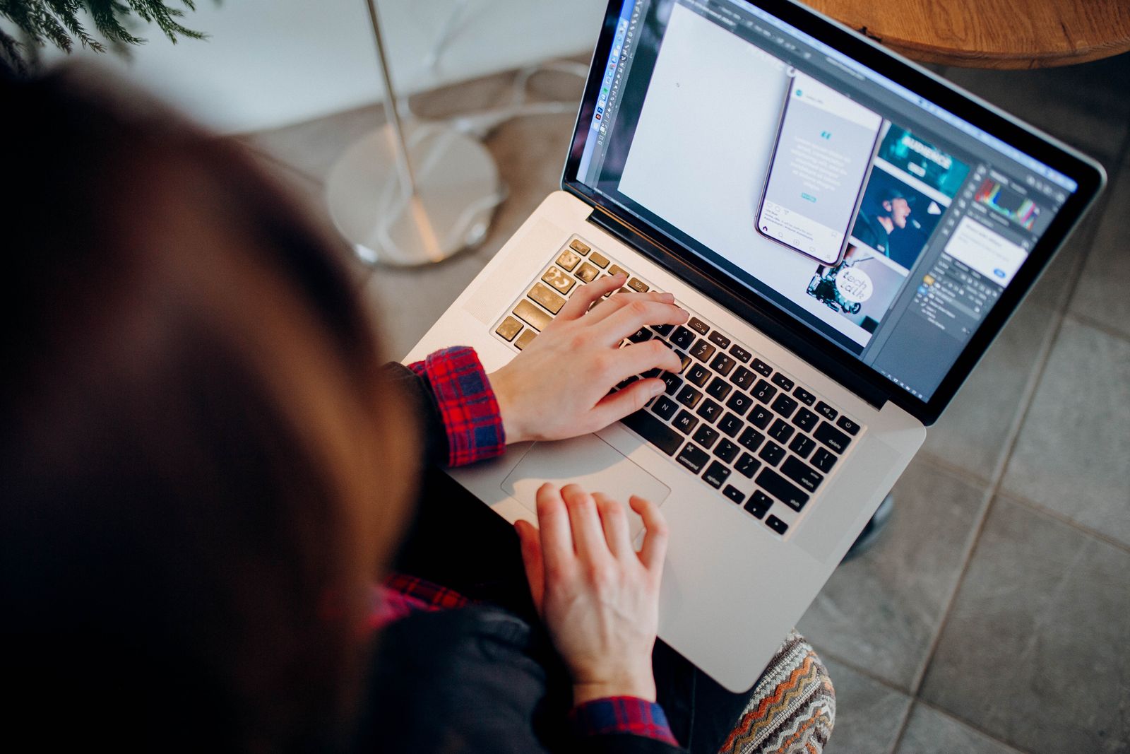 Person arbeitet an einem Laptop mit geöffneter Designsoftware