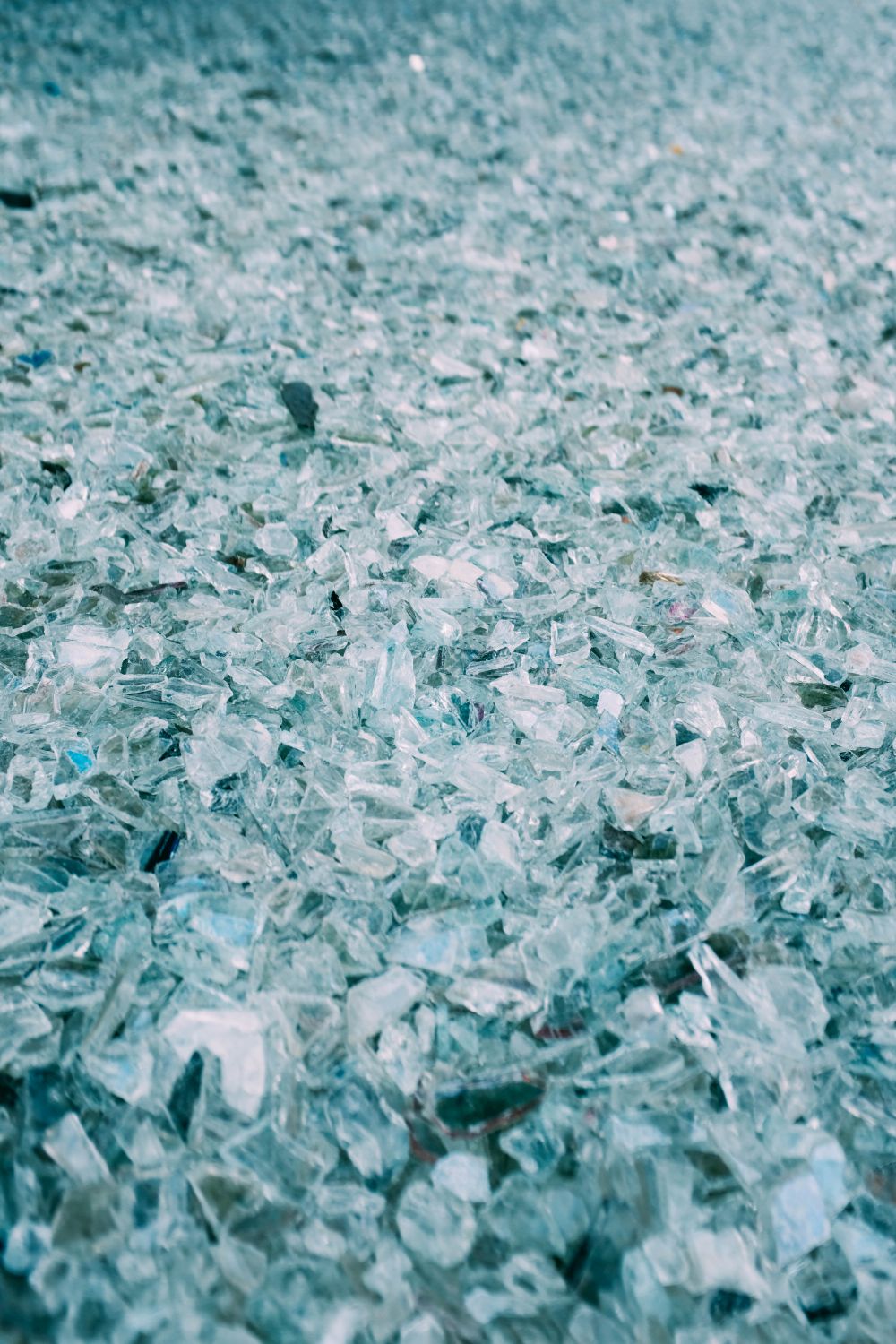 Nahaufnahme zersplitterter Glasstücke auf einer dunklen Fläche